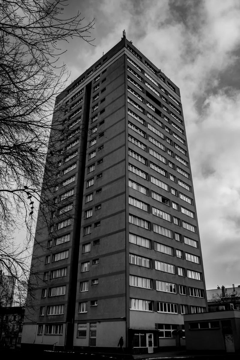Black-and-white view of a tall tower block rising upward